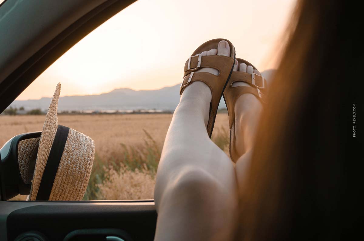 birkenstock-fashion-brand-shoes-gril-sitting-in-car-with-birkenstocks-on-legs-outside-the-window